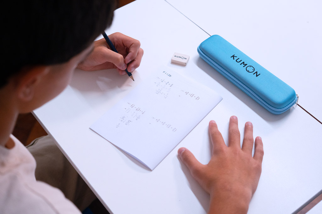 Alumno resolviendo ejercicios avanzados de matemáticas en un cuaderno Kumon, siguiendo un aprendizaje gradual y estructurado-Argentina