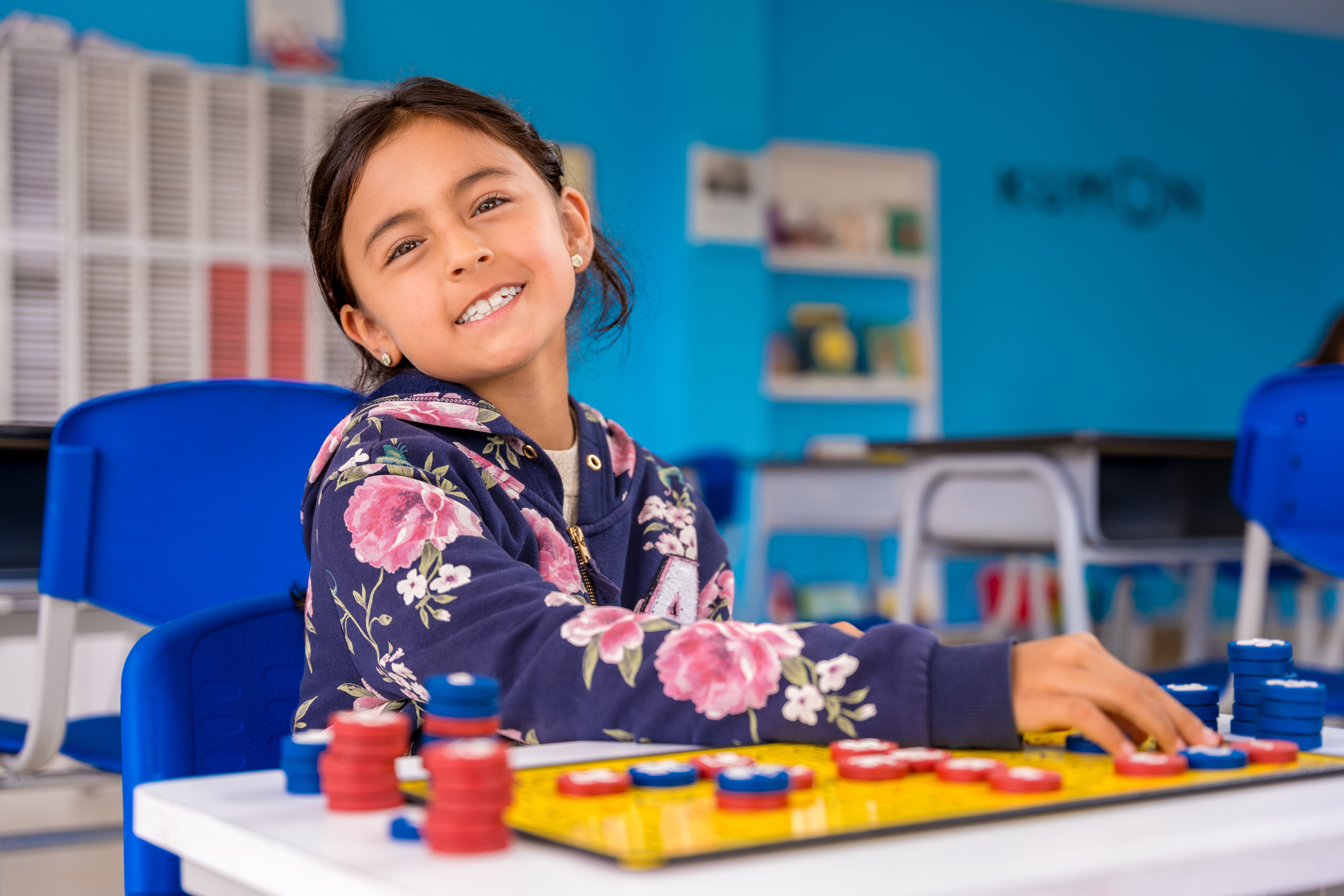 Niña estudiando matemáticas básicas con tablero magnético en un centro Kumon, disfrutando del aprendizaje-Argentina
