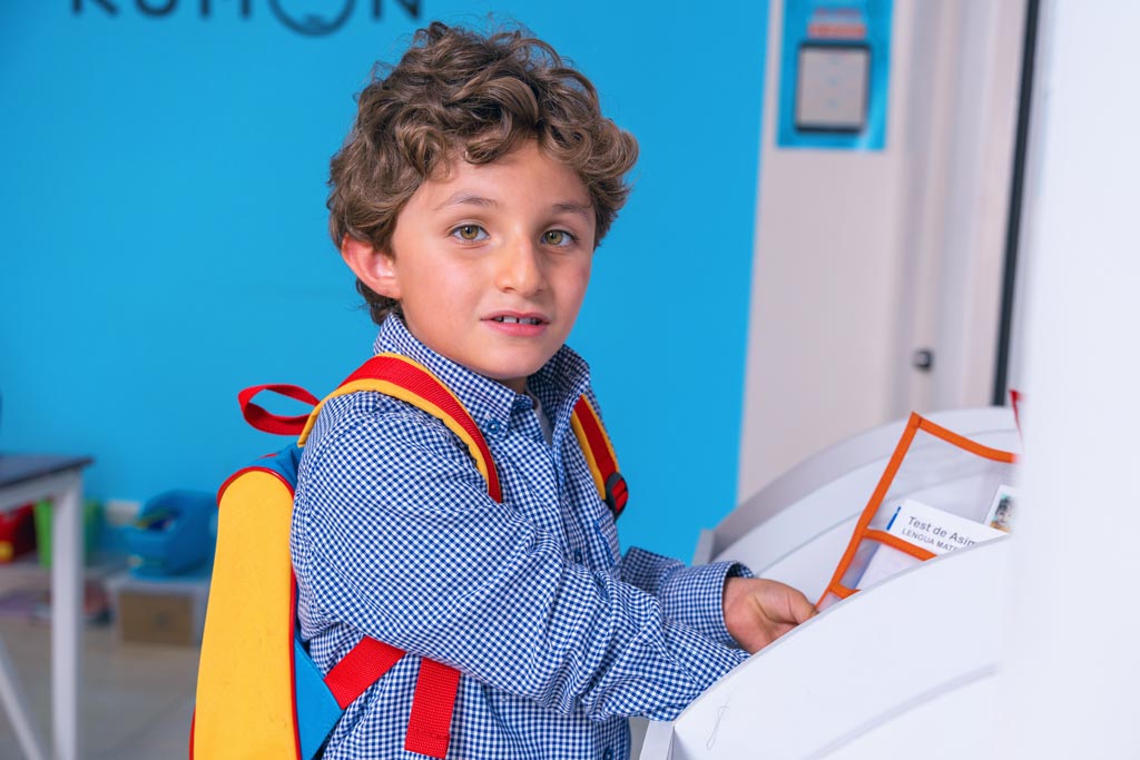 Niño entregando sus tareas en un centro Kumon, listo para continuar su aprendizaje con el método individualizado-Argentina