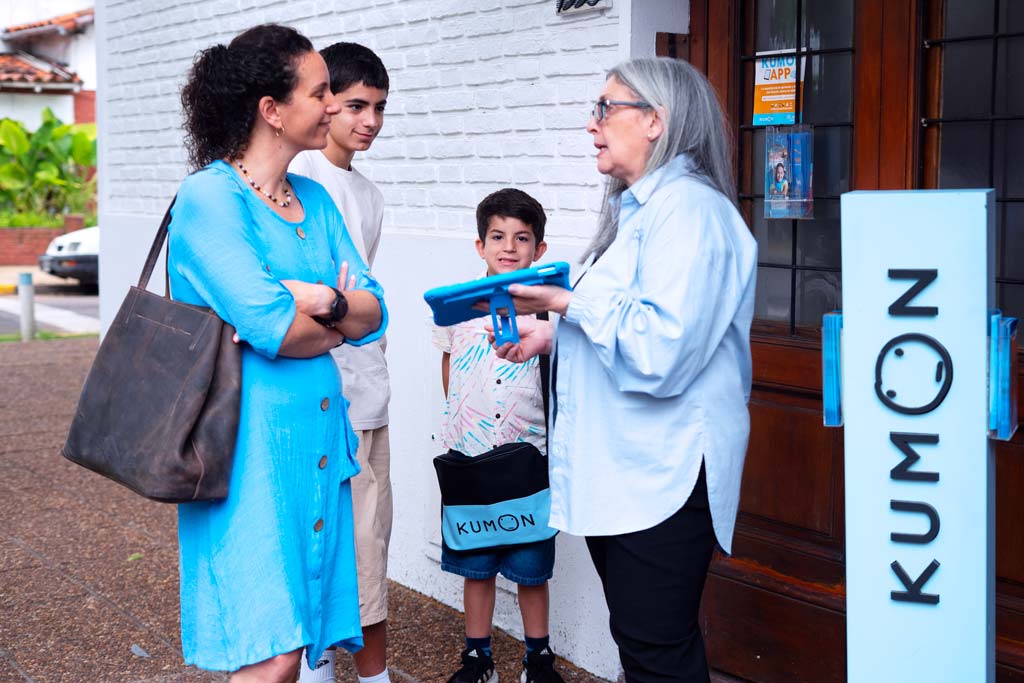Familia conversando con una orientadora frente a un centro Kumon-Argentina